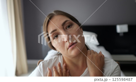 Woman suffering neck pain in hotel room 125598487