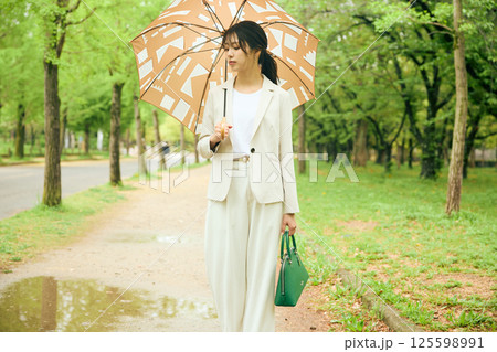 傘を差して歩く女性 125598991