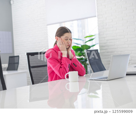 Caucasian woman makes mistake at work and holds her head. Caucasian woman makes mistake at work and holds her head. 125599009