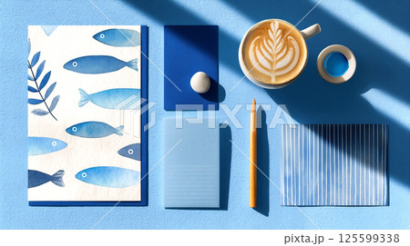 Creative workspace with blue-themed stationery and coffee on a bright table during the afternoon. 125599338