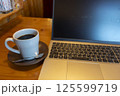 テーブルに置かれたノートパソコンとコーヒー 125599719