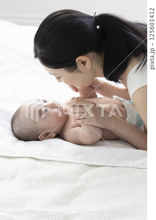 赤ちゃんにベビーマッサージをするママ 125601412