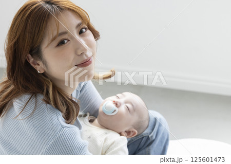 赤ちゃんを抱っこする可愛いママ 125601473