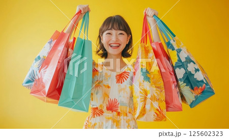 Happy young woman joyfully holds many colorful shopping bags. Happy young woman joyfully holds many colorful shopping bags. 125602323