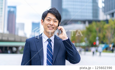 都市の中で仕事の電話をする男性 125602390
