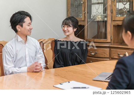 コンシェルジュ・ホテリエ・ウェディングプランナーと打ち合わせする男女(結婚相談所・結婚式場) コンシェルジュ・ホテリエ・ウェディングプランナーと打ち合わせする男女(結婚相談所・結婚式場) 125602965