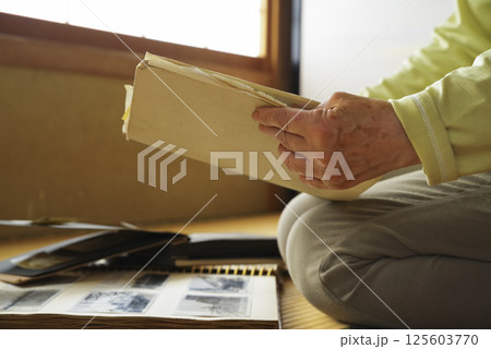 遺品整理で思い出にひたる老人 125603770