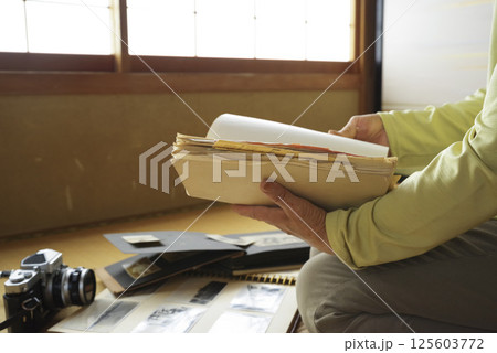 遺品整理で思い出にひたる老人 125603772