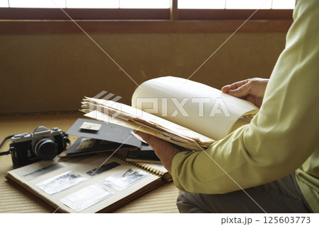 遺品整理で思い出にひたる老人 125603773