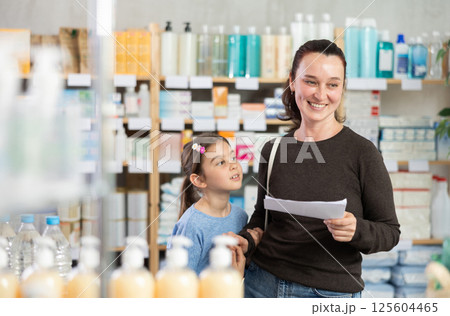 Woman with daughter choosing prescription drugs 125604465
