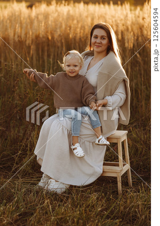 Mother and Daughter Smiling in Wheat Field at Sunset 125604594
