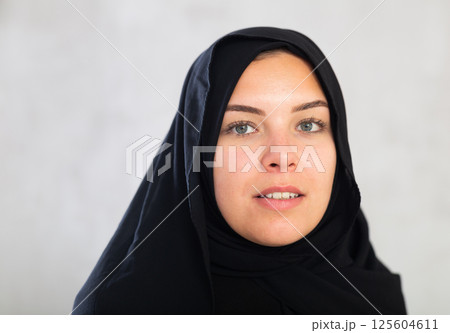 Cheerful young muslim woman dressed in black hijab 125604611