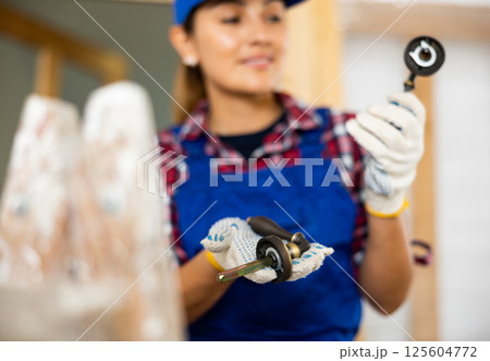 Woman builder demonstrates bronze door handles Woman builder demonstrates bronze door handles 125604772