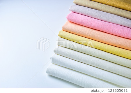 stack of colourful cotton clothes, pile of clothing on white background 125605051