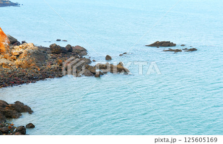 some weathered eroded cracked rocks on the coastline 125605169