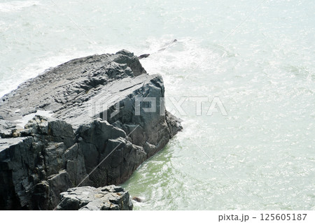 some weathered eroded cracked rocks on the coastline 125605187