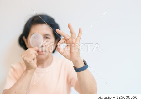 Elderly Woman with eye protective shield after eye surgery. Eye disease, Cataract,  Glaucoma, Age Related Macular Degeneration, Diabetic Retinopathy, Vitreous, Lasik, World Glaucoma day and health 125606360