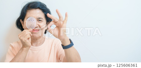Elderly Woman with eye protective shield after eye surgery. Eye disease, Cataract,  Glaucoma, Age Related Macular Degeneration, Diabetic Retinopathy, Vitreous, Lasik, World Glaucoma day and health 125606361