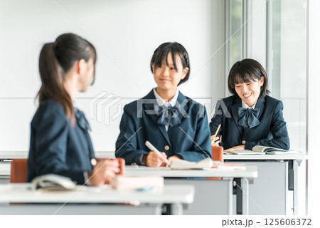 学校で授業中に後ろの席の生徒と話す小学生・中学生・高校生・女子高生（友達） 125606372