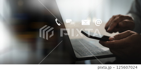 contact us Close up Man using smart phone chatting  contact us his office desk using a laptop computer global internet networking, social media 125607024