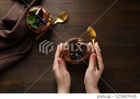 Chocolate mousse in a glass on a dark background. Chocolate mousse in a glass on a dark background. 125607430
