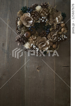 木目の壁に掛けられたクリスマスリース 125607676