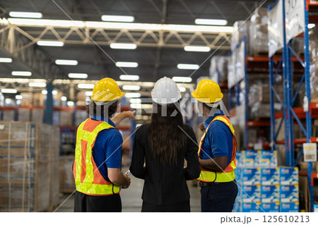 Warehouse workers multi-ethnic discussing work checking inventory and consulting distribution of product at warehouse storage department. Supervisor recommend the inspection and placement of goods 125610213