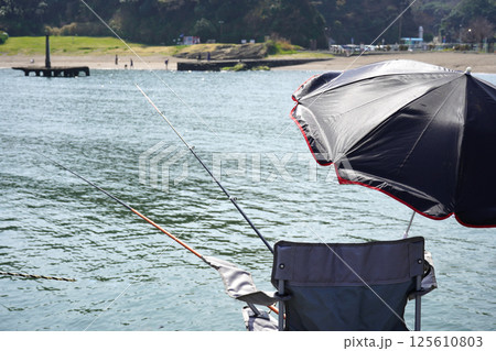 海に椅子から釣り竿を出した後ろからの撮影・海釣りのイメージ・趣味 125610803