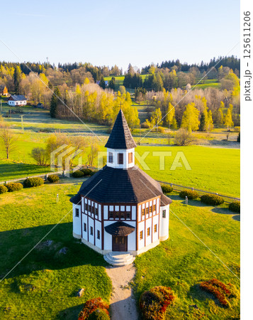 This aerial perspective highlights the unique octagonal shape of Tesarov Chapel in Korenov, surrounded by lush greenery and vibrant spring foliage in the Jizera Mountains. This aerial perspective highlights the unique octagonal shape of Tesarov Chapel in Korenov, surrounded by lush greenery and vibrant spring foliage in the Jizera Mountains. 125611206