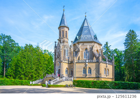 Located in Domanin near Trebon, Czechia, the Schwarzenberg Tomb features intricate Gothic architecture surrounded by lush greenery. Visitors admire its detailed design and historical significance. 125611236