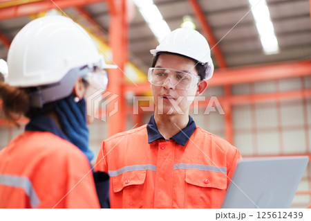 Team of Asian mechanical engineers is having a discussion inside the factory, with the chief engineer talking to his team. Engineer is briefing his team in the morning before they begin their work. Team of Asian mechanical engineers is having a discussion inside the factory, with the chief engineer talking to his team. Engineer is briefing his team in the morning before they begin their work. 125612439