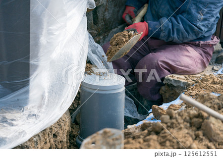 下水道工事 公共マスをシャベルで埋める土木作業員 下水道工事 公共マスをシャベルで埋める土木作業員 125612551