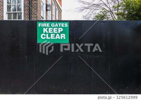 Fire Gates Keep Clear safety sign on black metal gate for emergency access and fire safety Fire Gates Keep Clear safety sign on black metal gate for emergency access and fire safety 125612999