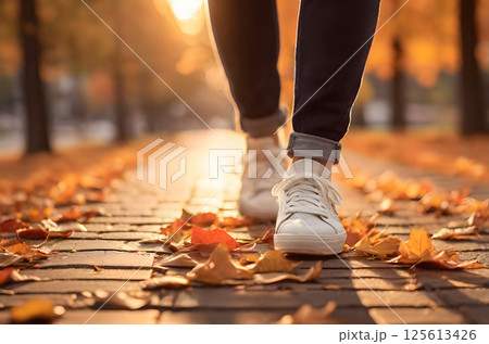 white sneakers on the grass covered with fall foliage white sneakers on the grass covered with fall foliage 125613426