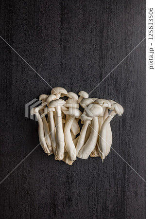 Raw white shimeji mushrooms on black table. Top view. Raw white shimeji mushrooms on black table. Top view. 125613506