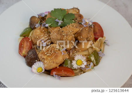 Delicious chicken, linguine, shiitake mushrooms, and garden flowers pasta dish for a delightful 125613644