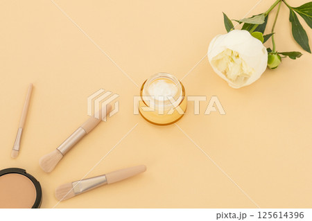 Women cosmetics set and a peony flower. Women cosmetics set and a peony flower. 125614396