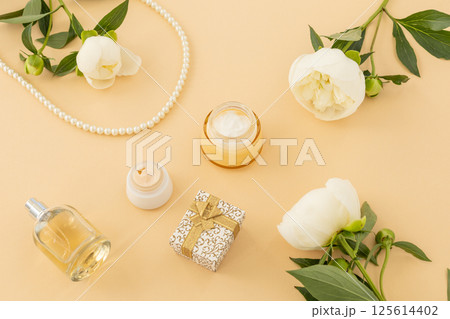 Women cosmetics set with costume jewelry and peony flowers. 125614402