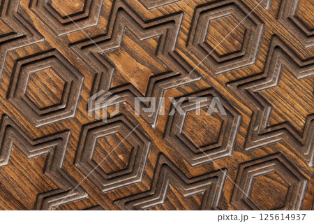 Carved wooden texture featuring geometric patterns of stars and hexagons Carved wooden texture featuring geometric patterns of stars and hexagons 125614937
