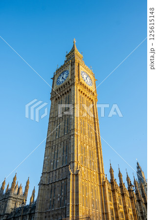 Big Ben rises majestically against a clear blue sky in London. This famous clock tower, part of the Palace of Westminster, showcases stunning architecture and rich history. 125615148
