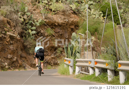 Woman cyclist in the ravine of Arguineguin. Woman cyclist in the ravine of Arguineguin. 125615191