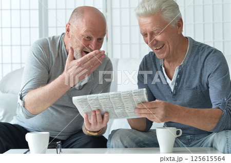 Two old men sitting at table and discussing news 125615564