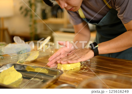 Man wearing black gloves forming compound butter for wrapping 125616249