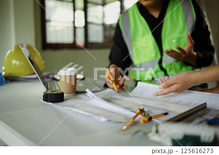 Close up of engineers discussing blueprints at a construction site table 125616273