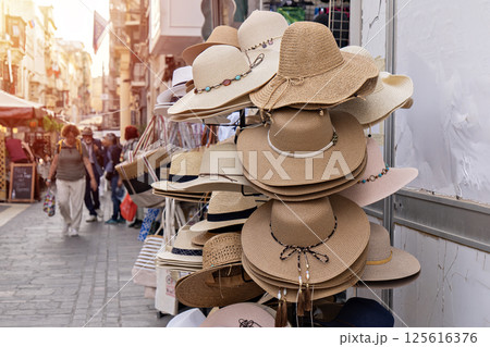 Sun hats in city street capture mood of summer season, season of warmth reflected in woven tones, season-inspired scene fits lifestyle visuals and travel storytelling 125616376