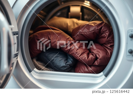 Winter jackets in front-loading washing machine before wash 125616442