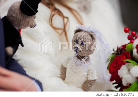 Soft toys dressed in wedding attire are carried by the bride and groom Soft toys dressed in wedding attire are carried by the bride and groom 125616773