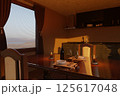 Glasses, candles on a wooden table in a cozy kitchen, filled with warm evening light 125617048