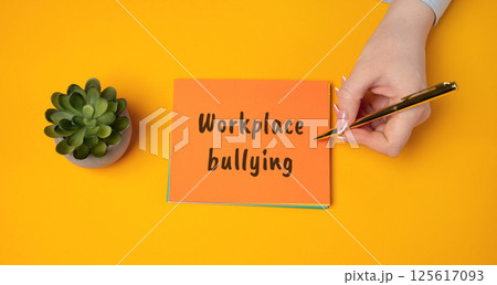 Workplace bullying concept. Form of aggressive behavior where an individual or group repeatedly mistreats others in a work environment. A woman writes a message in a notepad 125617093