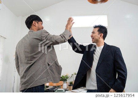 Professional Collaboration and Agreement. Two colleagues sharing a positive moment after resolving a conflict. Professional Collaboration and Agreement. Two colleagues sharing a positive moment after resolving a conflict. 125617954